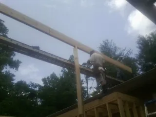 Carpenter setting a ridge beam over a new addition frame — Ice Dam Removal by Roofing Brothers in Seaton
